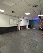 TA WingTsun Seelze - Professioneller Kampfkunst-Trainingsraum mit freier Bodenfläche, Neonwand, Deckenbeleuchtung und spezieller Ausstattung für Technik, Koordination und Partnerübungen.