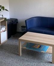 Ein Pausenbereich mit Couch und Couchtisch.