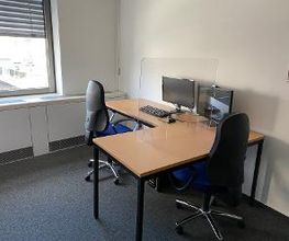 Ein Arbeitsplatz mit Eckschreibtisch, zwei Monitoren und Maus und Tastatur.