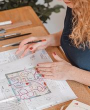 Webstudio Dresden Kreativer Arbeitsprozess am Tisch, Frau zeichnet Grundriss mit Markern, Symbol für Planung und visuelle Konzepte.