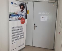 Ein Flur mit einem WBS Training Schild und einer Eingangstür