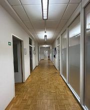 Ein Bild vom Flur. Links befinden sich geöffnete Türen zu Räumen.