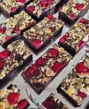 dean&david Catering | Pforzheim - Schokoladen-Brownies mit Himbeeren, Mandeln, Kürbiskernen und Sonnenblumenkernen auf Servierplatte als süßes Dessert für Buffet und Catering.