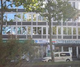 WBS TRAINING Gebäude hinter einem Baum an einer Straße