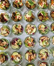dean&david Catering | Pforzheim - Frische Salate im Glas mit Falafel, Hummus, Minze, Granatapfel und knackigem Gemüse neben Chicken Bowls mit Limette für vielseitiges Event Catering.