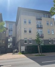 Gebäude mit mehreren Fenstern. Davor steht ein Briefkasten und ein Baum.