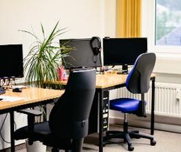 Arbeitsplätze mit PC und blauen Stühlen