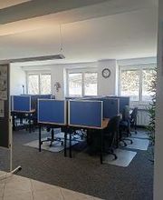 Arbeitsplätze mit Bildschirm, Stühlen und Unterteilungen