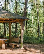 Eine Überdachte Sitzgruppe schützt Besucher des FriedWald Bremer Schweiz vor Regen und Wind.