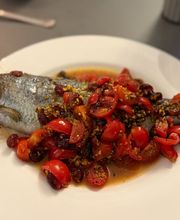 Geschlossene Gesellschaft Ganzer Fisch mit Tomaten und Kräutern, kreativ zubereitet und präsentiert bei Geschlossene Gesellschaft Hamburg.
