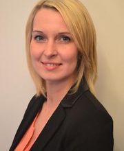 eine blonde junge Frau in Bluse und Sakko.