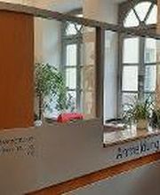 Empfangsbereich des Standortes mit Tresen, Tisch und Pflanzen.