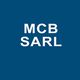 M C B