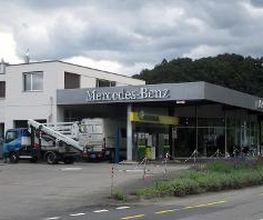 AGROLA Tankstelle in Gümmenen bei Mercedes-Benz; links im Bild Totem mit AGROLA Logo und Preisschildern darunter Selecta Automat
